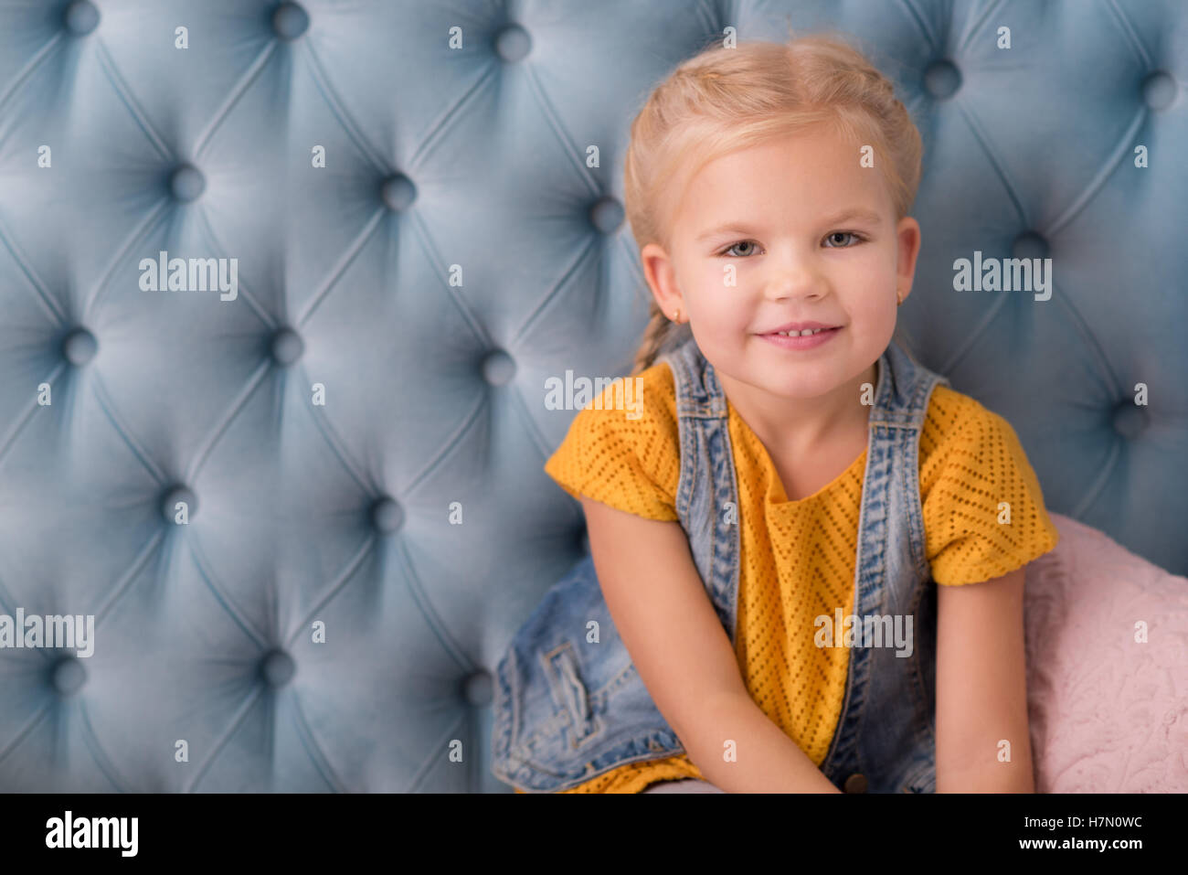 Cheerful adorable girl sitting on the sofa Stock Photo - Alamy