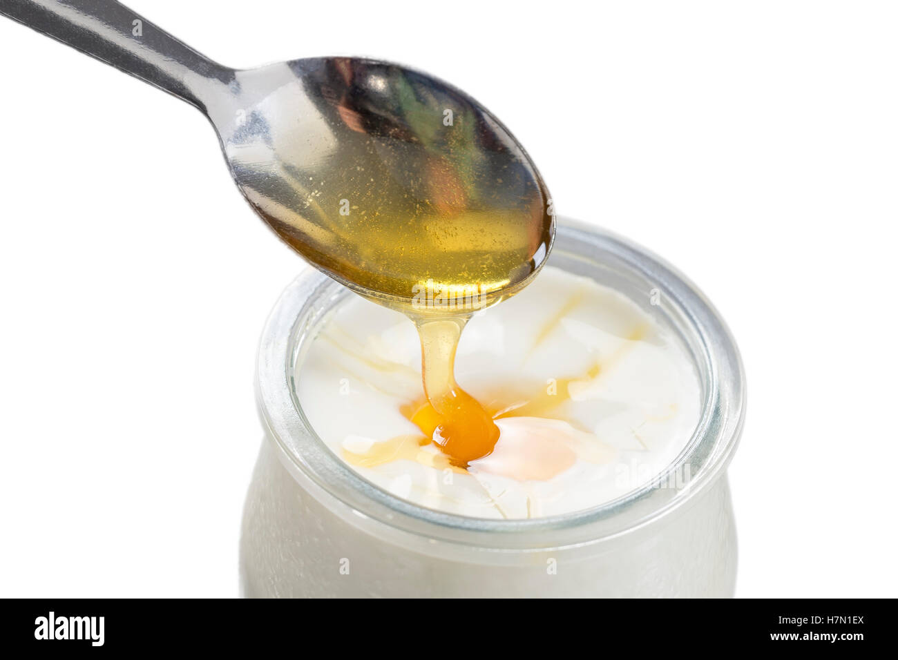 Yogurt and pouring honey on white background Stock Photo