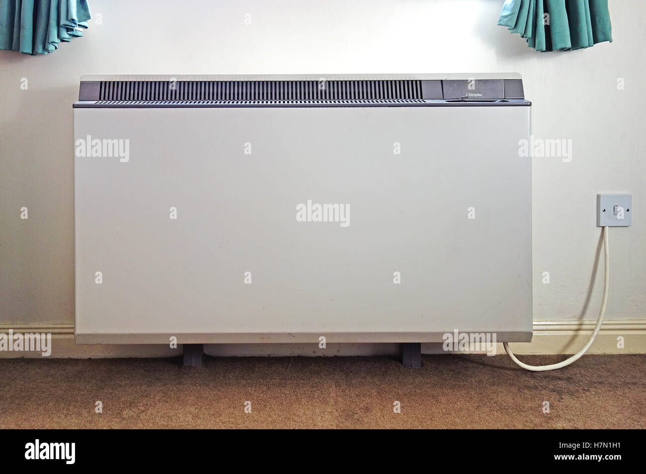 an electric night storage heater fitted on the wall inside a home Stock Photo