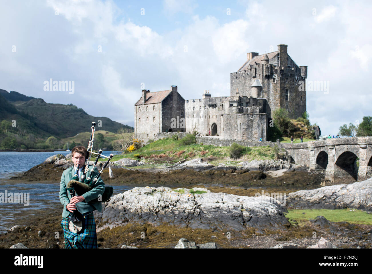 Pipebag player in front of Eilean Donan Castle Isle of Sky Scotland United Kingdom 20.05.2016 Stock Photo