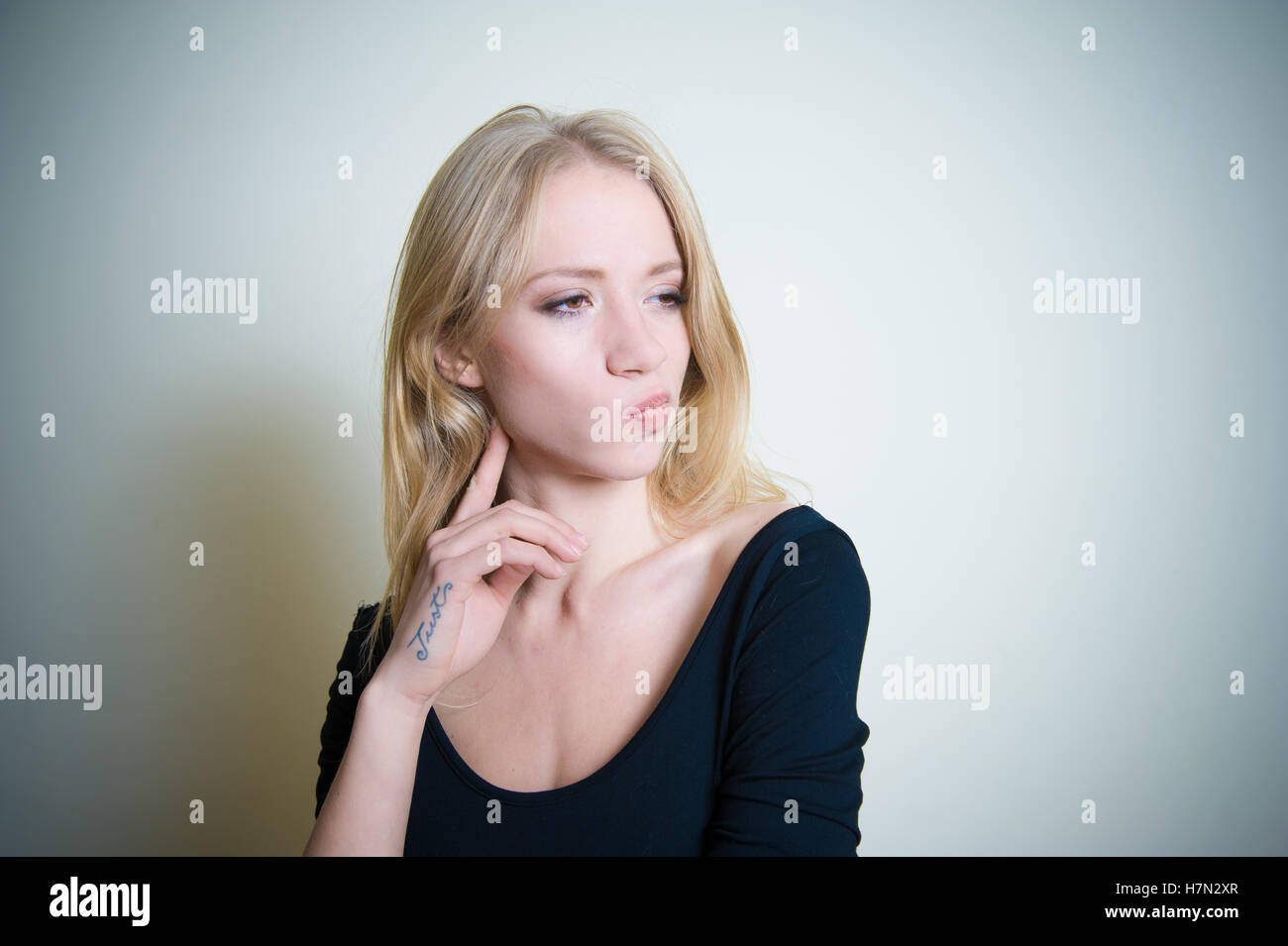 Young blond woman thoughtful looking side, portrait with copy space Stock Photo