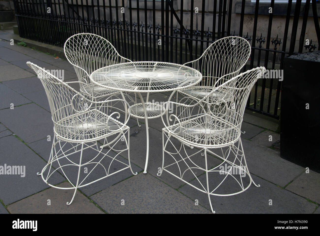 set of  4 white wrought iron table and chairs Stock Photo