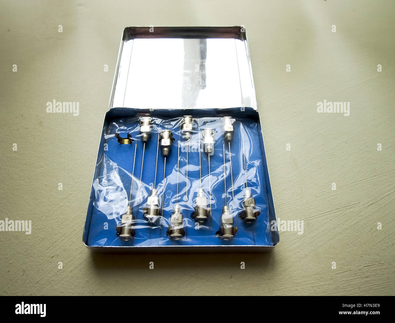 An old tin containing reusable hypodermic needles Stock Photo