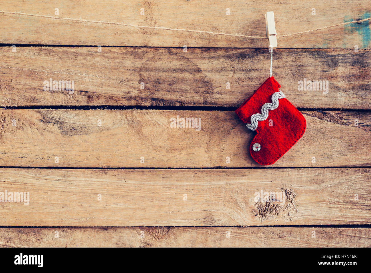 red sock for Santa gifts hanging over rustic wooden background. christmas stocking Stock Photo