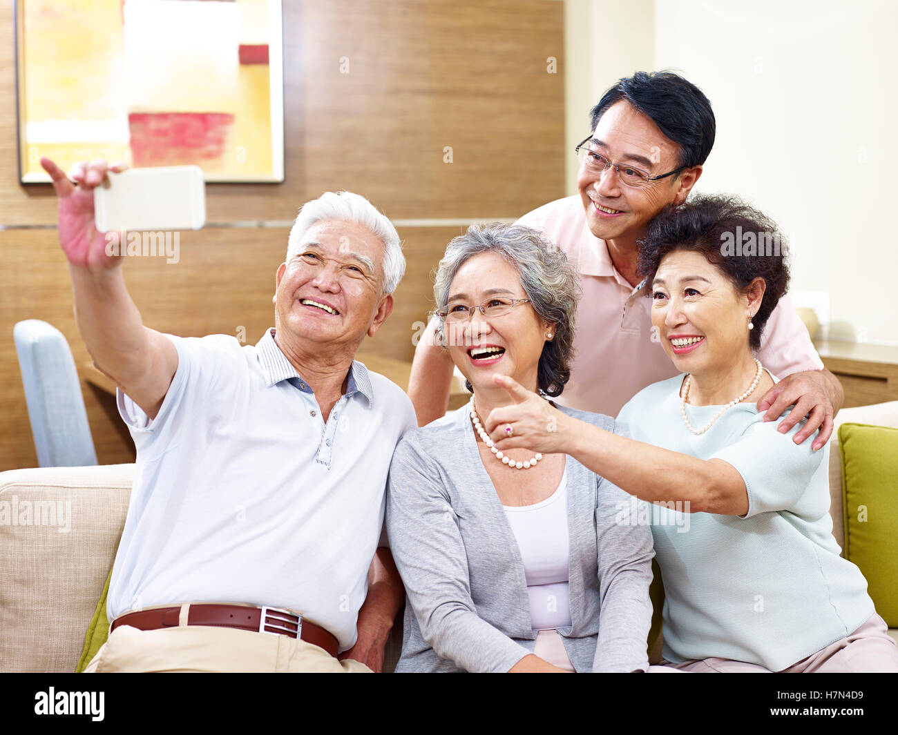 two senior couples taking a selfie on couch at home Stock Photo