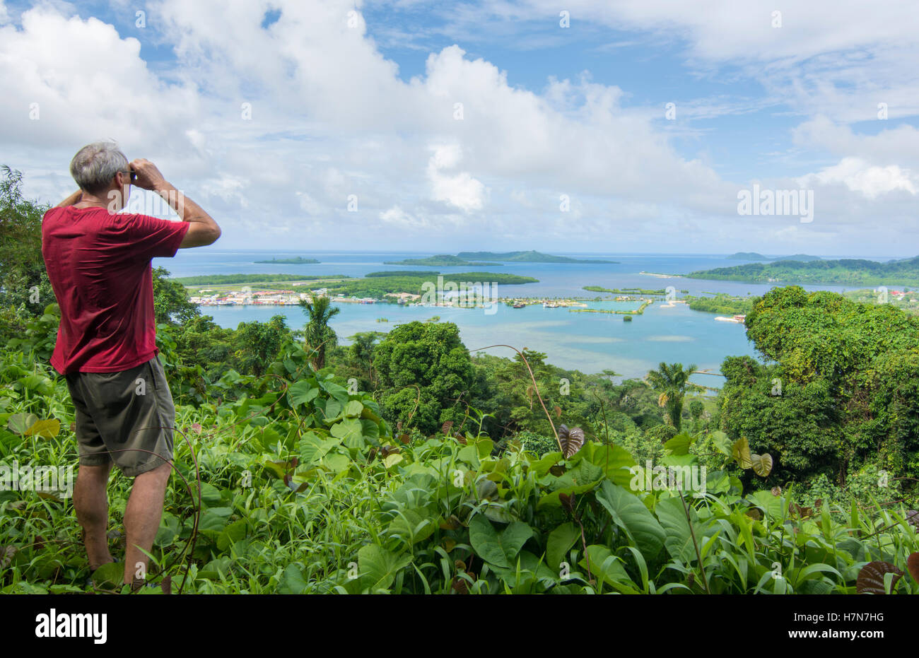 Sokehs Ridge Pohnpei Micronesia man with binoculars looking at city of Kolonia from ...