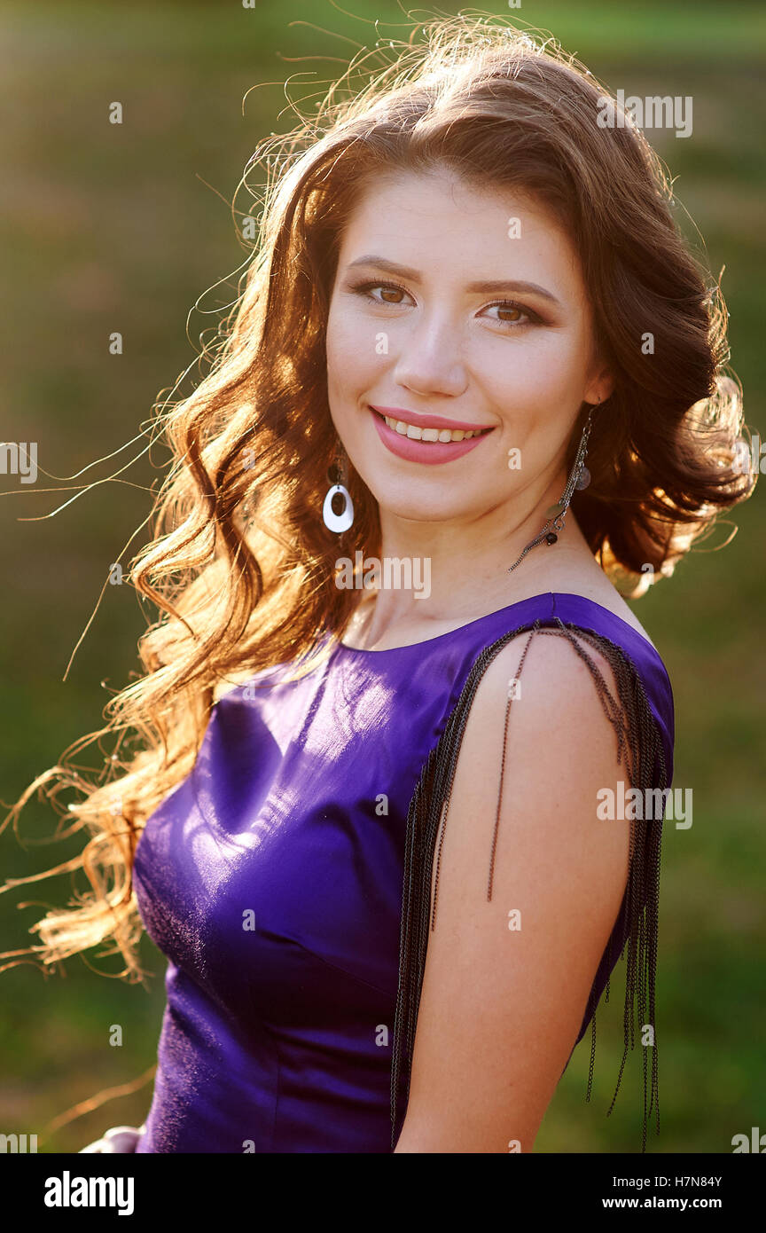 beautiful woman in a purple dress on the meadow Stock Photo