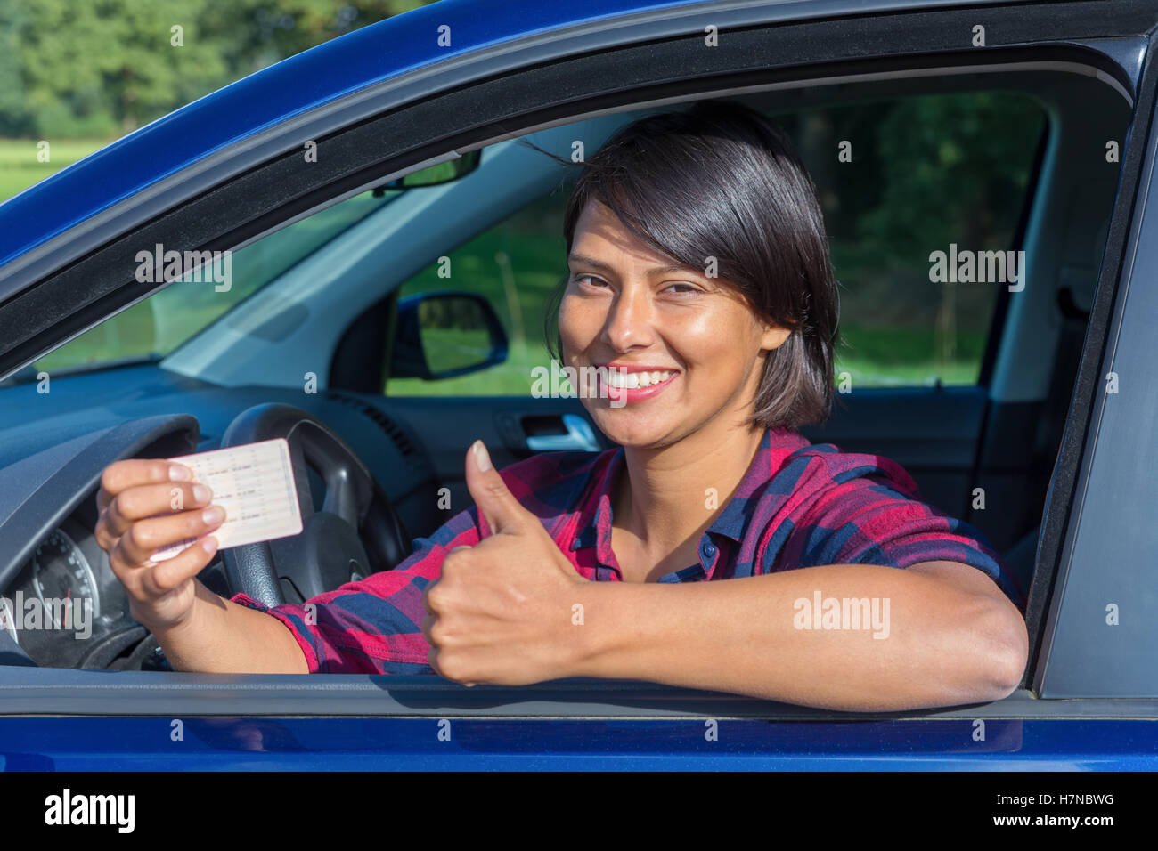 Young european woman showing driving license in car Stock Photo