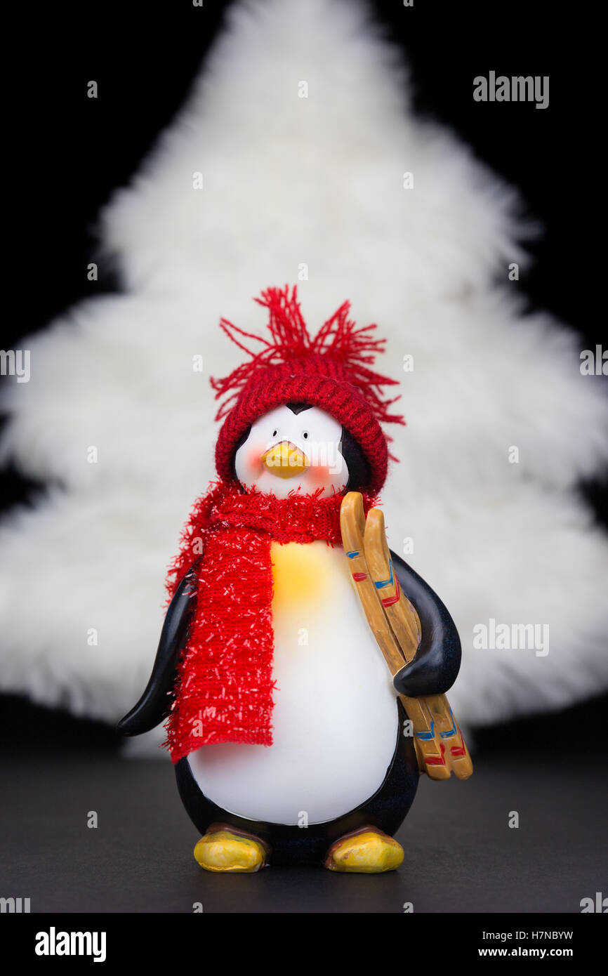 Penguin figurine with white christmas tree isolated on black background Stock Photo