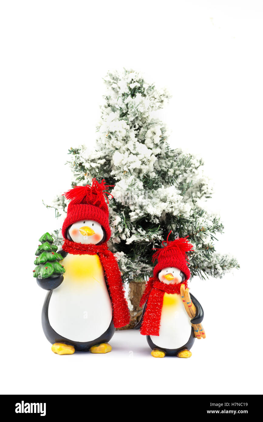 Two penguin figurines with christmas tree in winter isolated on white background Stock Photo