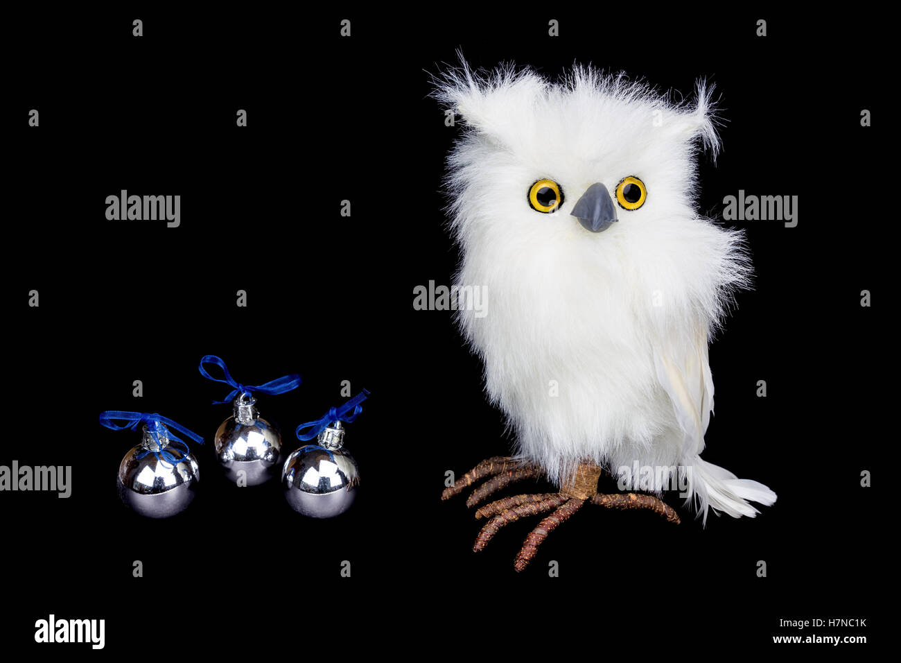 White snowy owl figurine with silver christmas balls isolated on black background Stock Photo