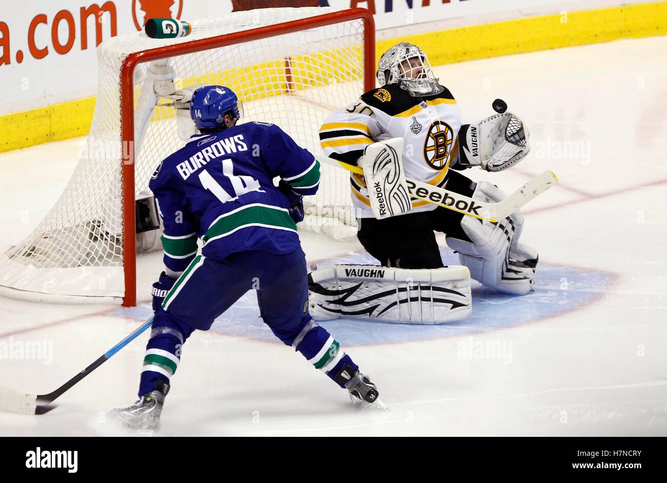 June 1, 2011; Vancouver, BC, CANADA; Boston Bruins goalie Tim Thomas (30) makes a save as Vancouver Canucks left wing Alex Burrows (14) looks on during the third period in game one of the 2011 Stanley Cup Finals at Rogers Arena. Stock Photo