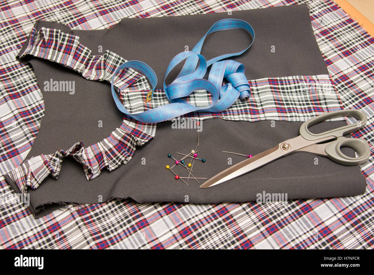 Top view of the child billet school dress lying on the table with sewing accessories Stock Photo