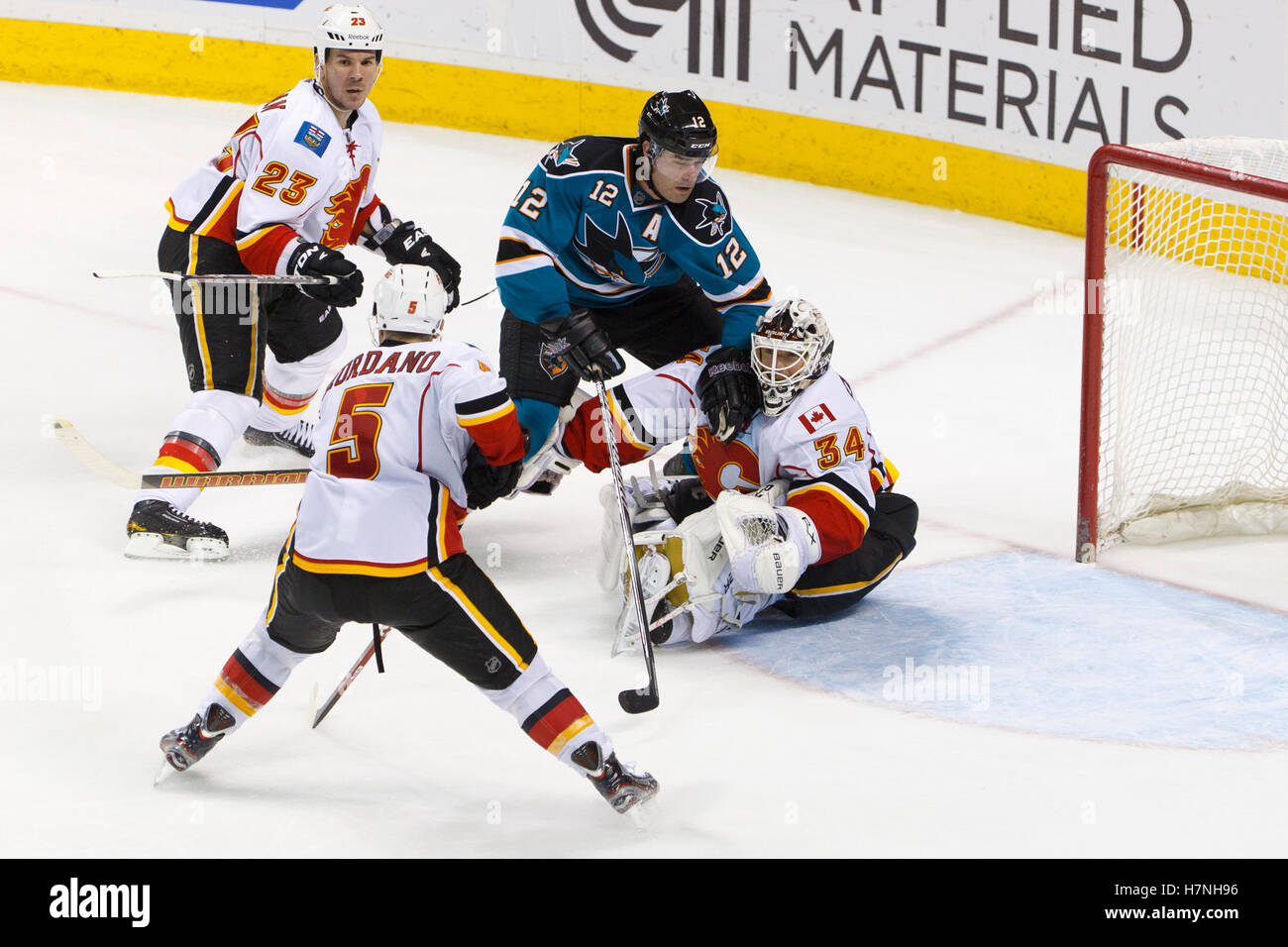Feb 8, 2012; San Jose, CA, USA; San Jose Sharks left wing Patrick Marleau (12) collides with Calgary Flames goalie Miikka Kiprusoff (34) in front of the goal during the third period at HP Pavilion. Calgary defeated San Jose 4-3. Stock Photo