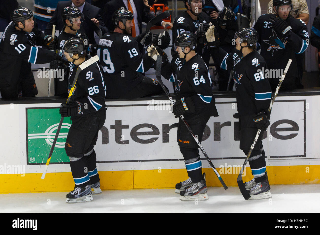 Feb 10, 2012; San Jose, CA, USA; San Jose Sharks left wing Jamie McGinn (64) is congratulated by teammates after scoring a goal against the Chicago Blackhawks during the third period at HP Pavilion. San Jose defeated Chicago 5-3. Stock Photo