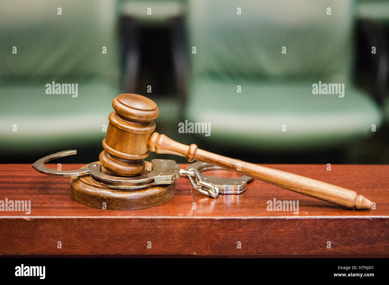 Criminal Law, gavel and handcuffs in courtroom by jury box Stock Photo