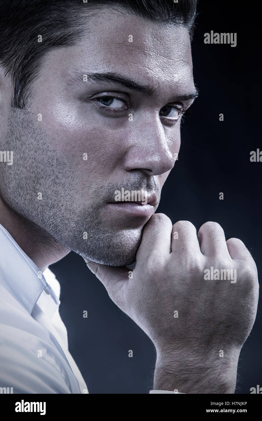 Handsome young man with dark beard stubble and modern hairstyle in