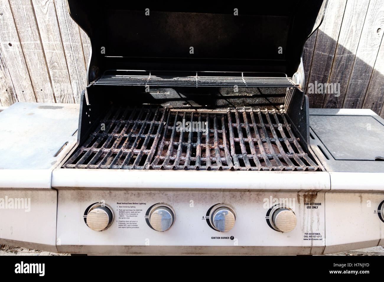 A  propane gas grill with lid open showing rust and a deteriorating condition. USA. Stock Photo