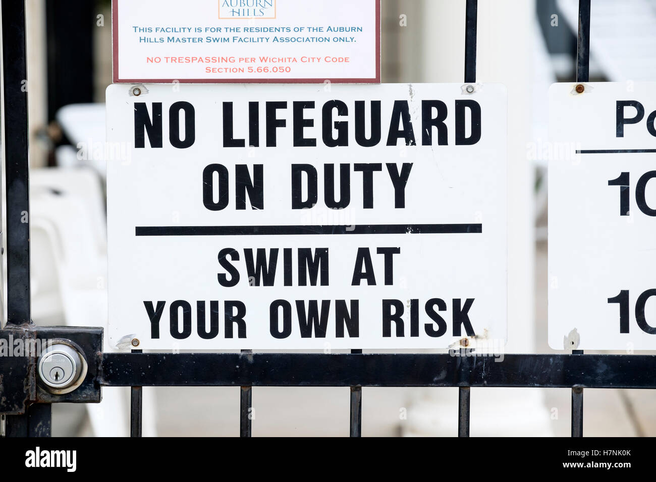 A sign stating no lifeguard on duty, swim at your own risk, for a private swimming pool for a