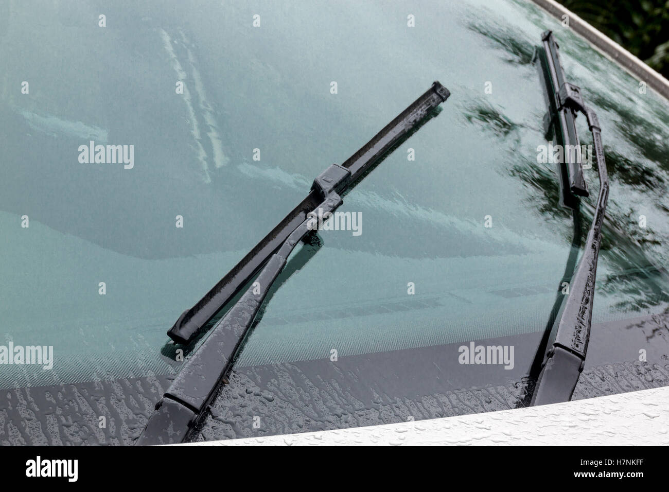 Close up of wet windshield reflections patterns textures and wiper blades and arms Stock Photo