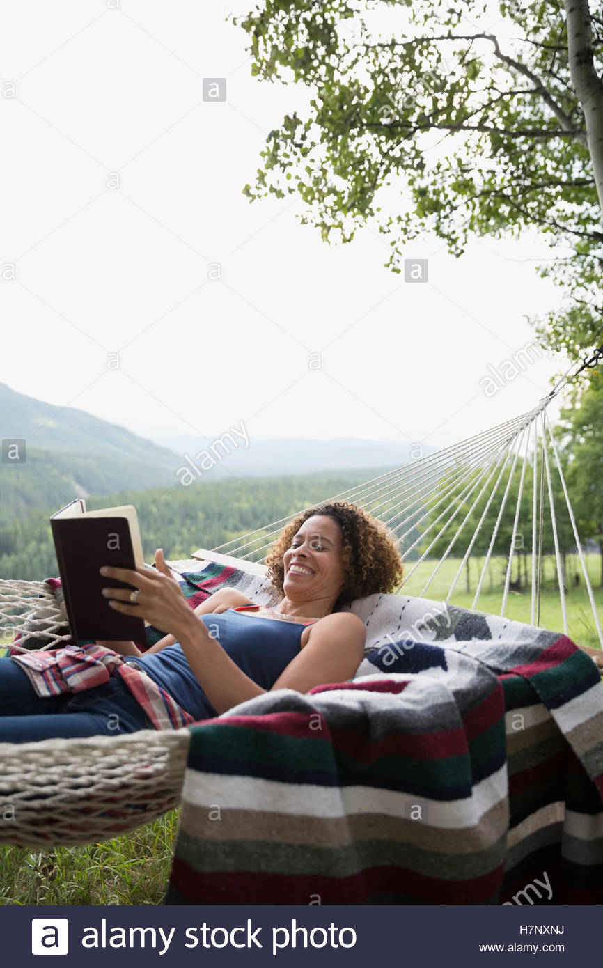 Woman reading book in rural hammock Stock Photo - Alamy