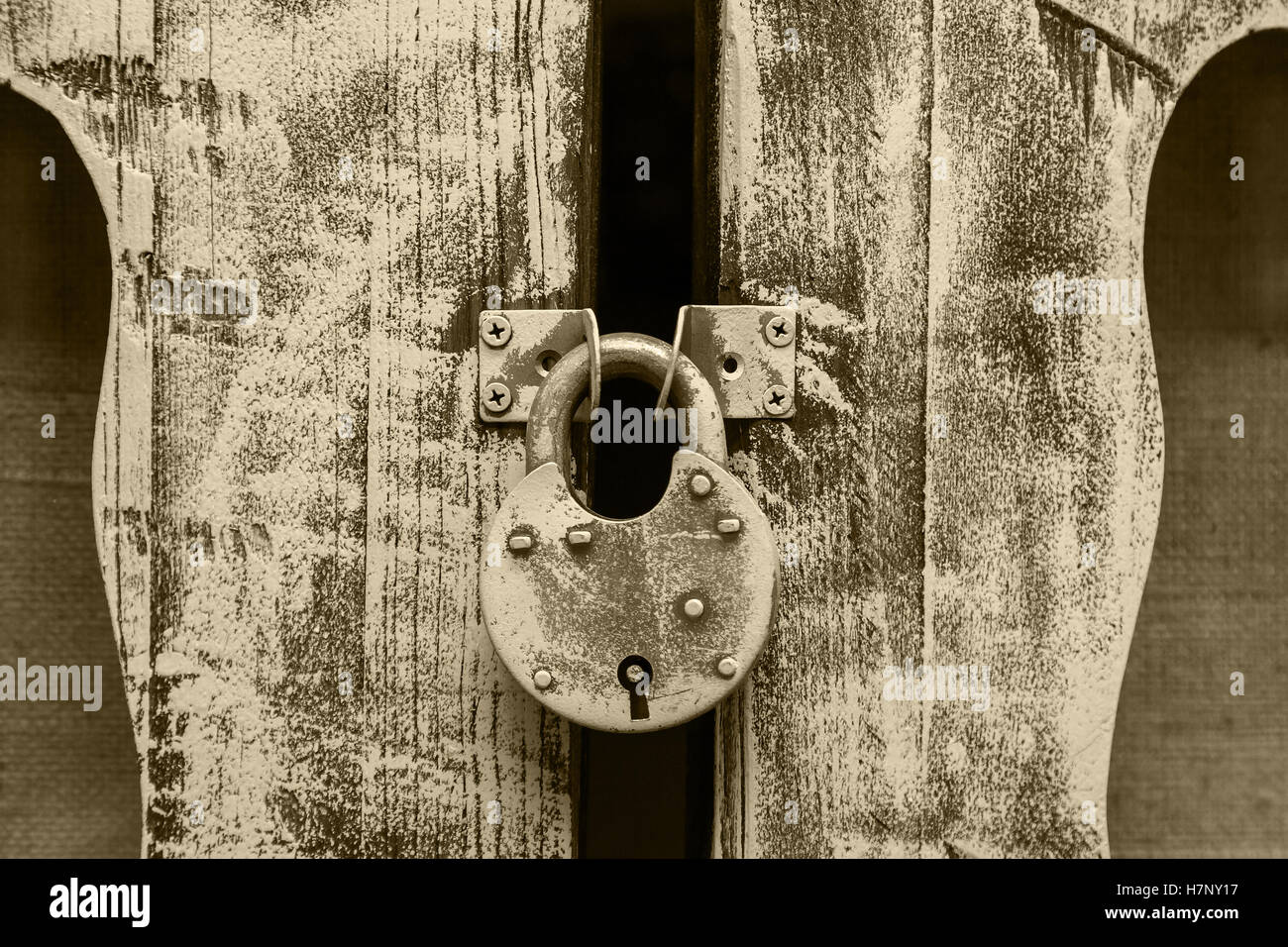 closed old metal lock hanging on wooden door hinges Stock Photo - Alamy