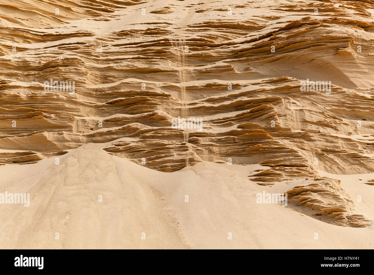Sand falls. Beautiful view of the sand falls on the sculptured sandy mountains. Stock Photo