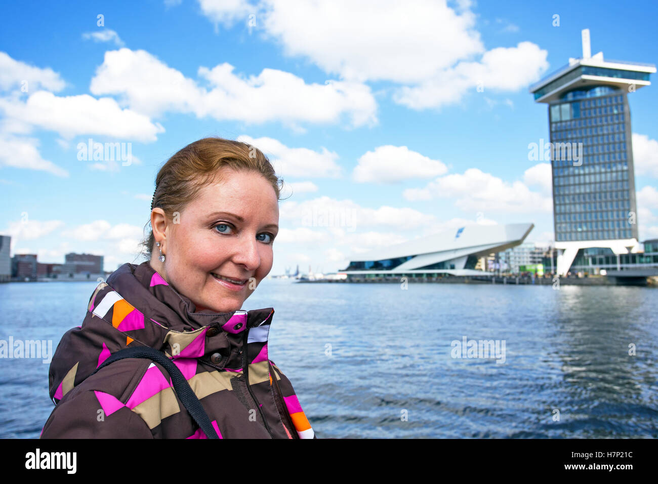 Young native dutch woman in the harbor from Amsterdam in the Netherlands Stock Photo