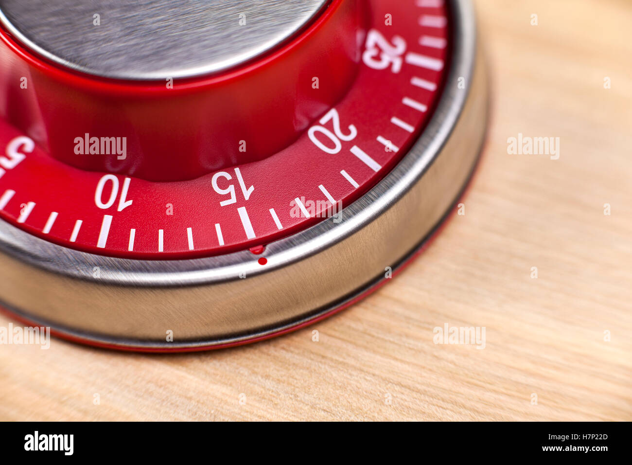 Macro view of a red kitchen egg timer showing 15 minutes on wooden background Stock Photo