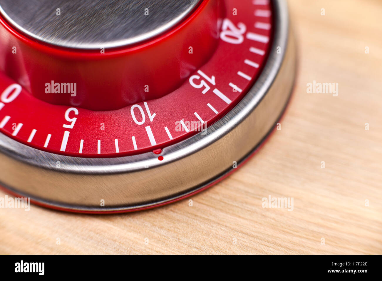 Macro view of a red kitchen egg timer showing 10 minutes on wooden background Stock Photo