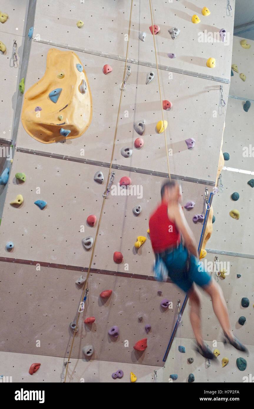Man Climbing with Ropes on Climbing Wall Stock Photo