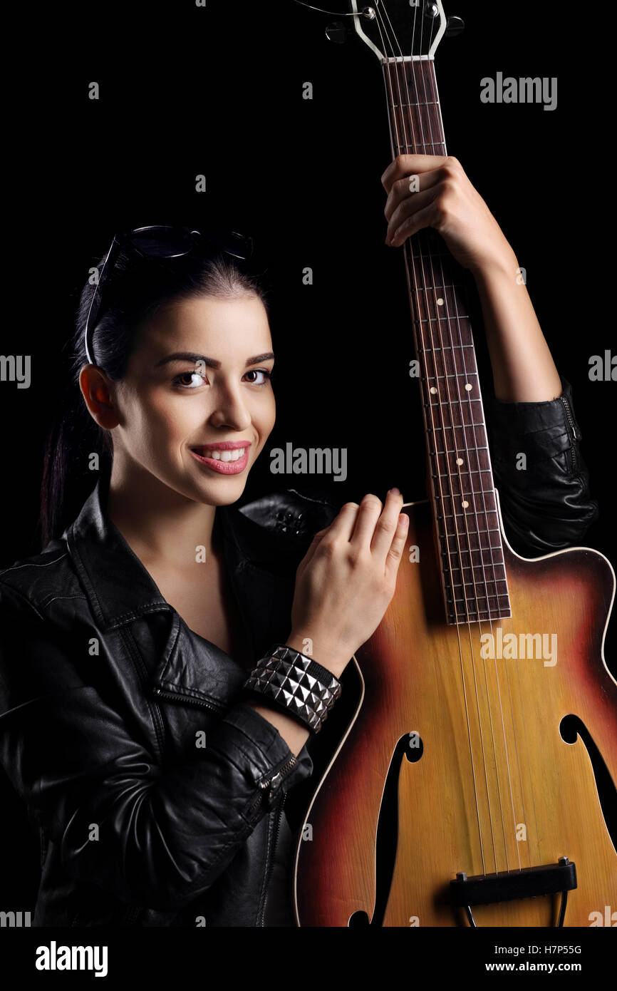 Young woman with an acoustic guitar isolated on black background Stock ...