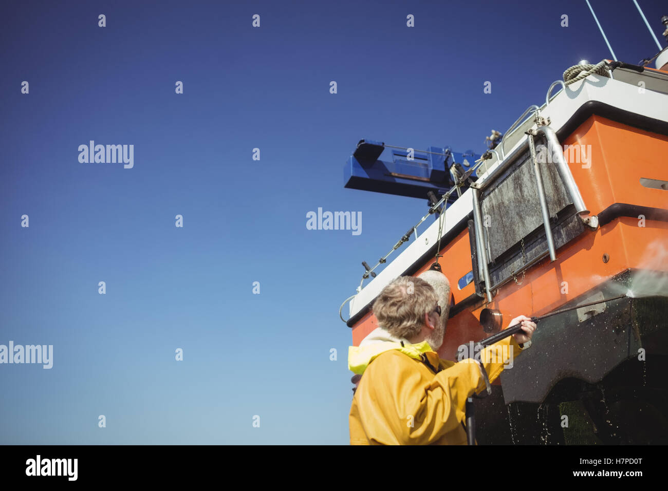 Man cleaning boat with pressure washer Stock Photo Alamy