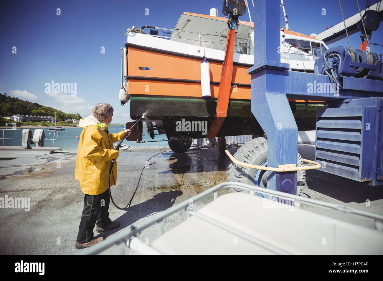 Man cleaning boat with pressure washer Stock Photo Alamy