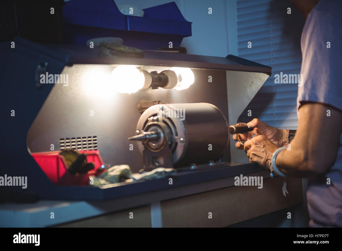 Mid-section of craftswoman working on a machine Stock Photo