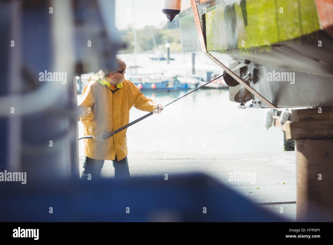 Man cleaning boat with pressure washer Stock Photo Alamy