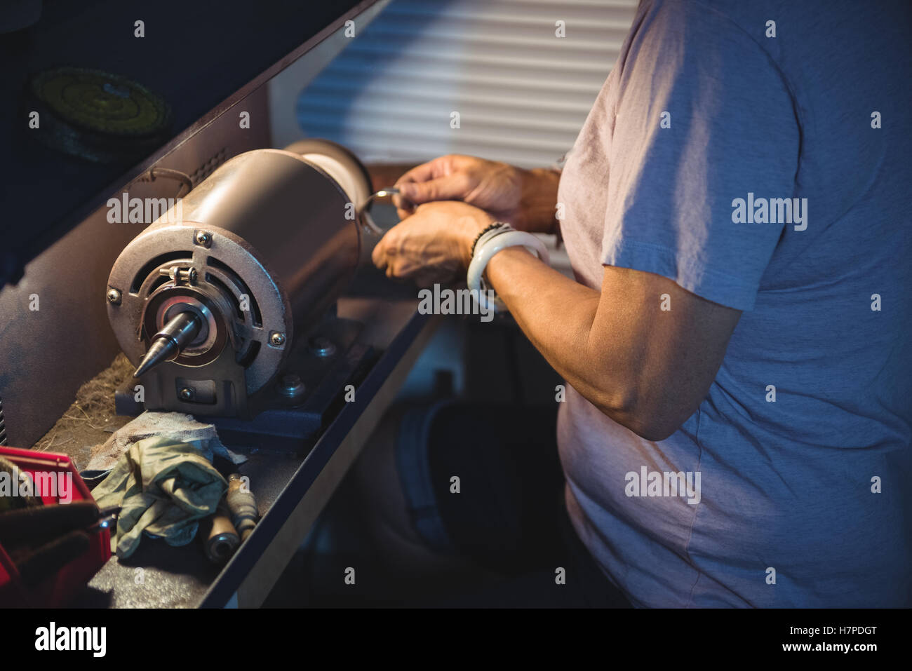 Mid-section of craftswoman working on a machine Stock Photo