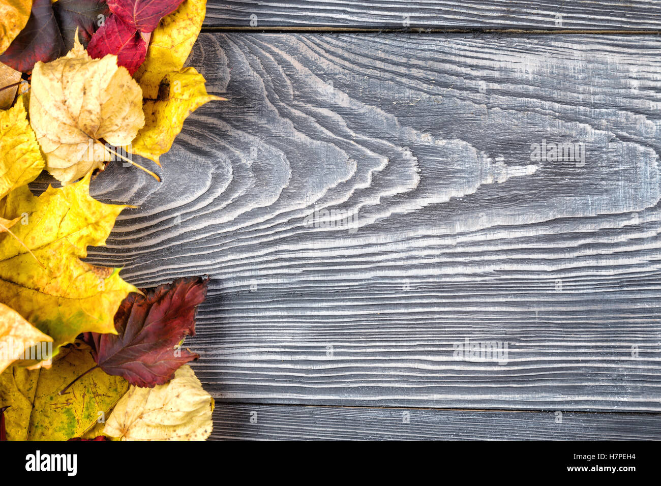 Wooden background with autumn leaves on the left edge Stock Photo - Alamy