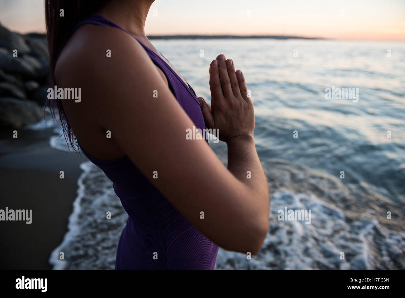 Mid section of woman meditating on beach Stock Photo