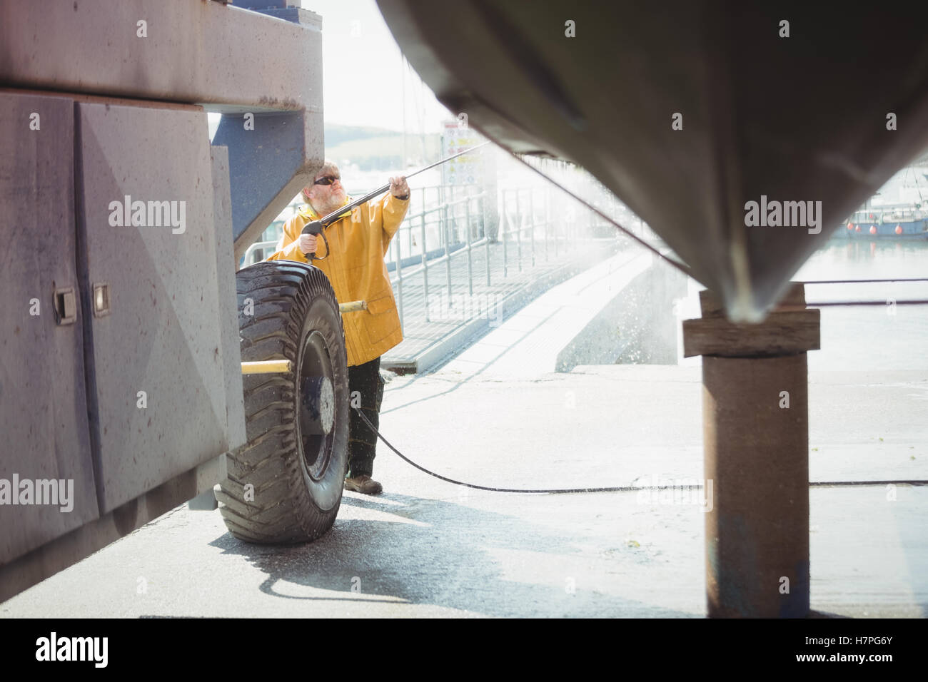 Man cleaning boat with pressure washer Stock Photo Alamy