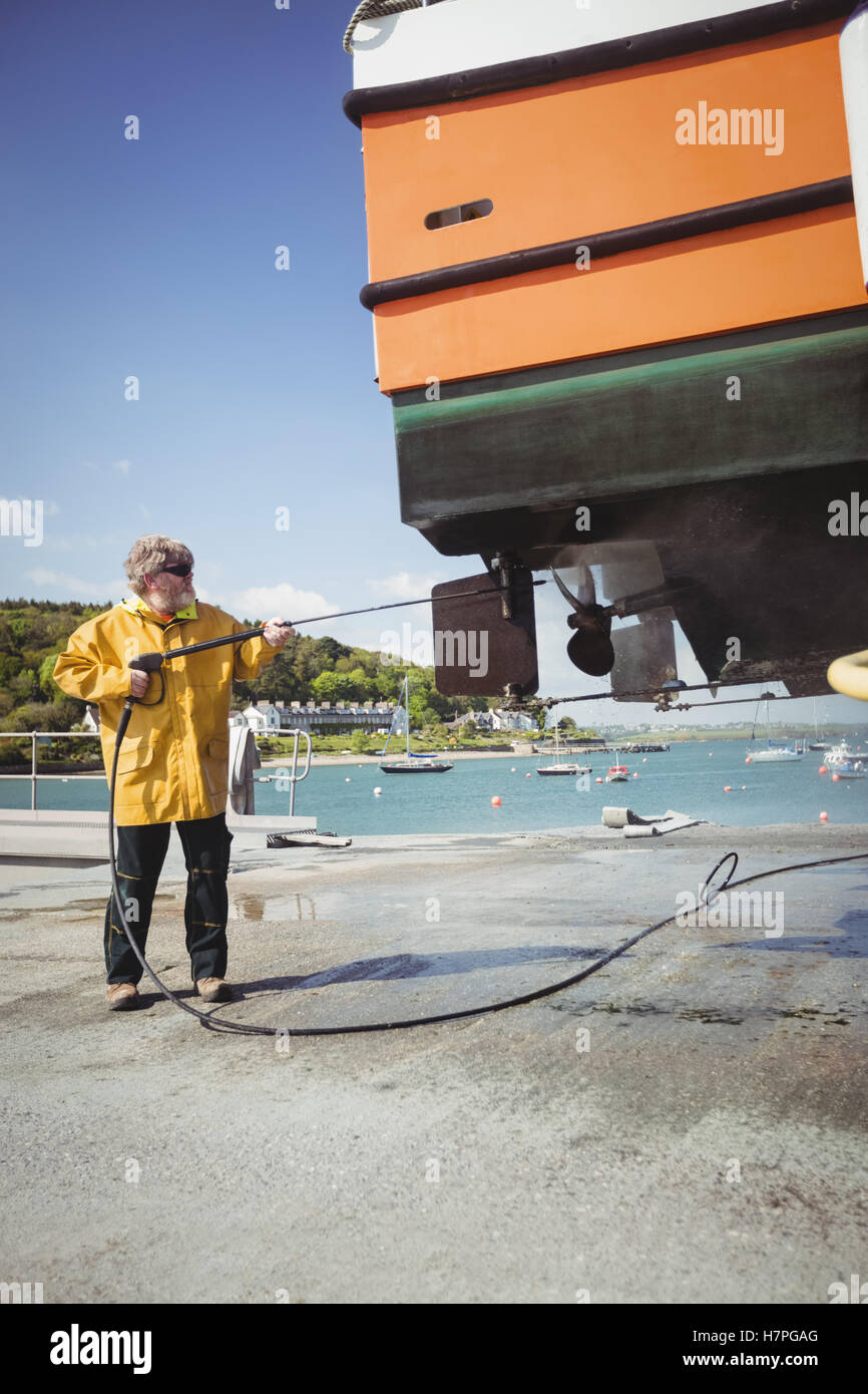 Man cleaning boat with pressure washer Stock Photo Alamy