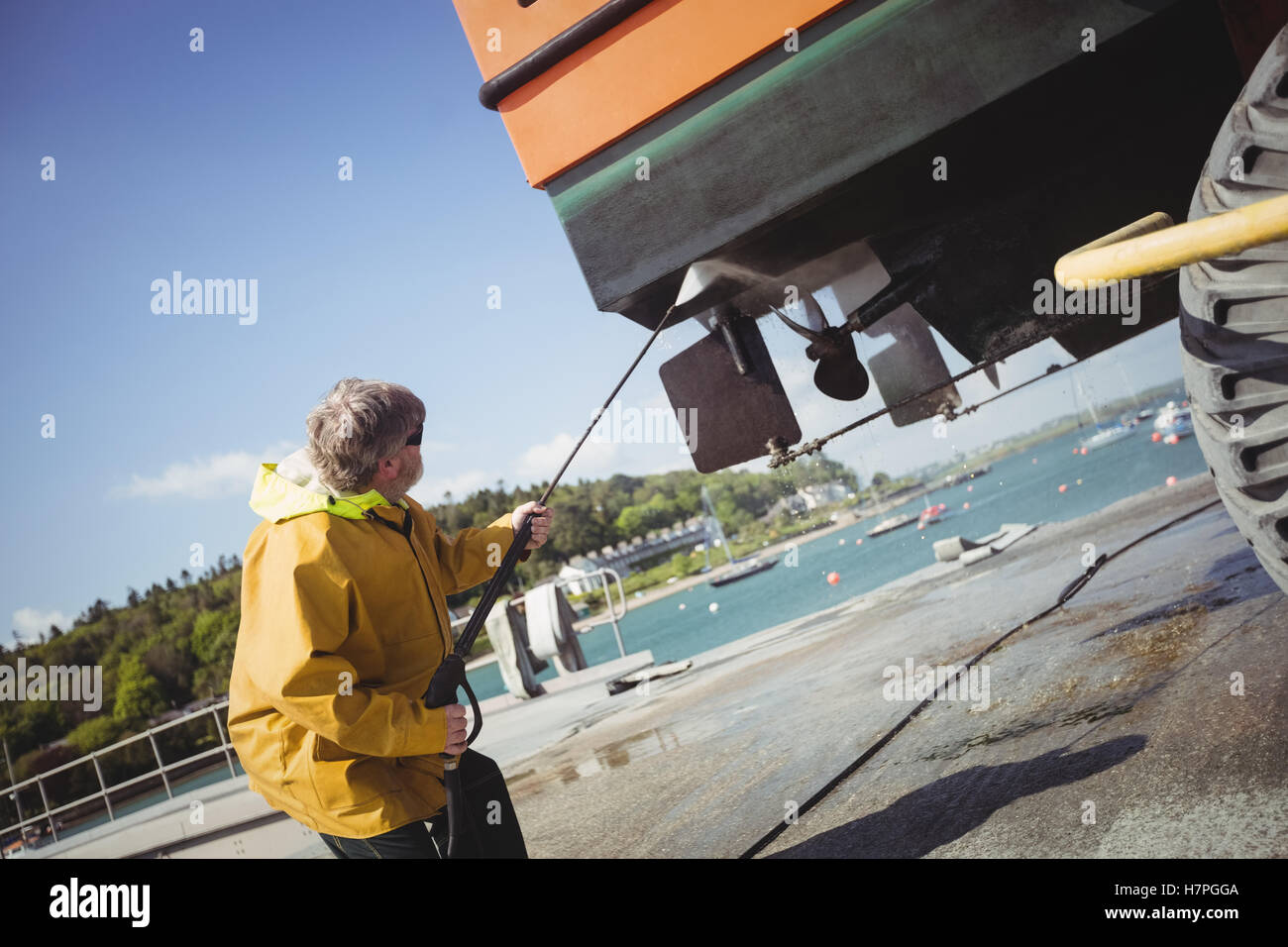 Man cleaning boat with pressure washer Stock Photo Alamy