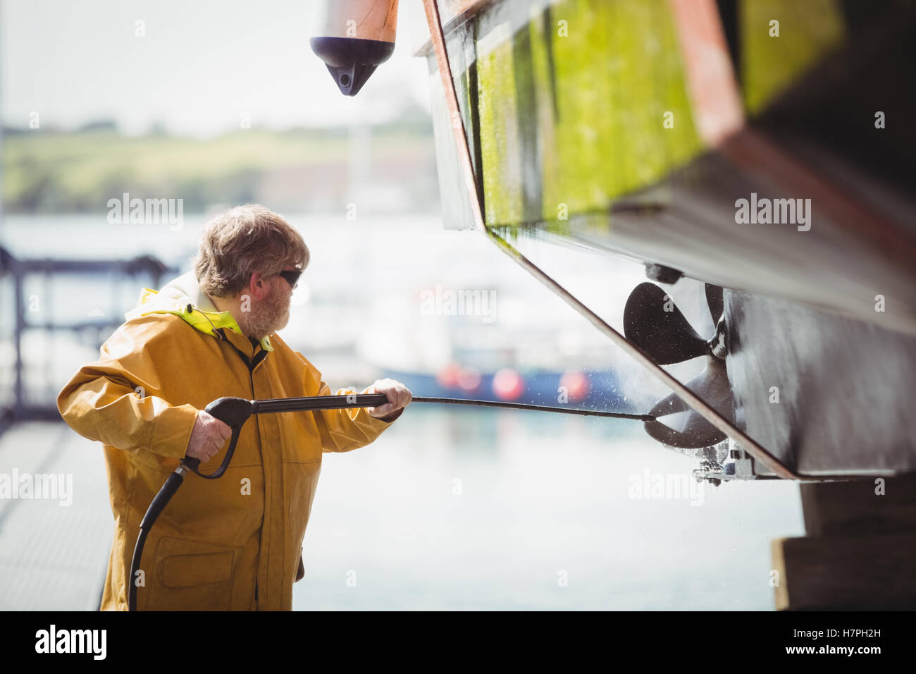 Man cleaning boat with pressure washer Stock Photo Alamy