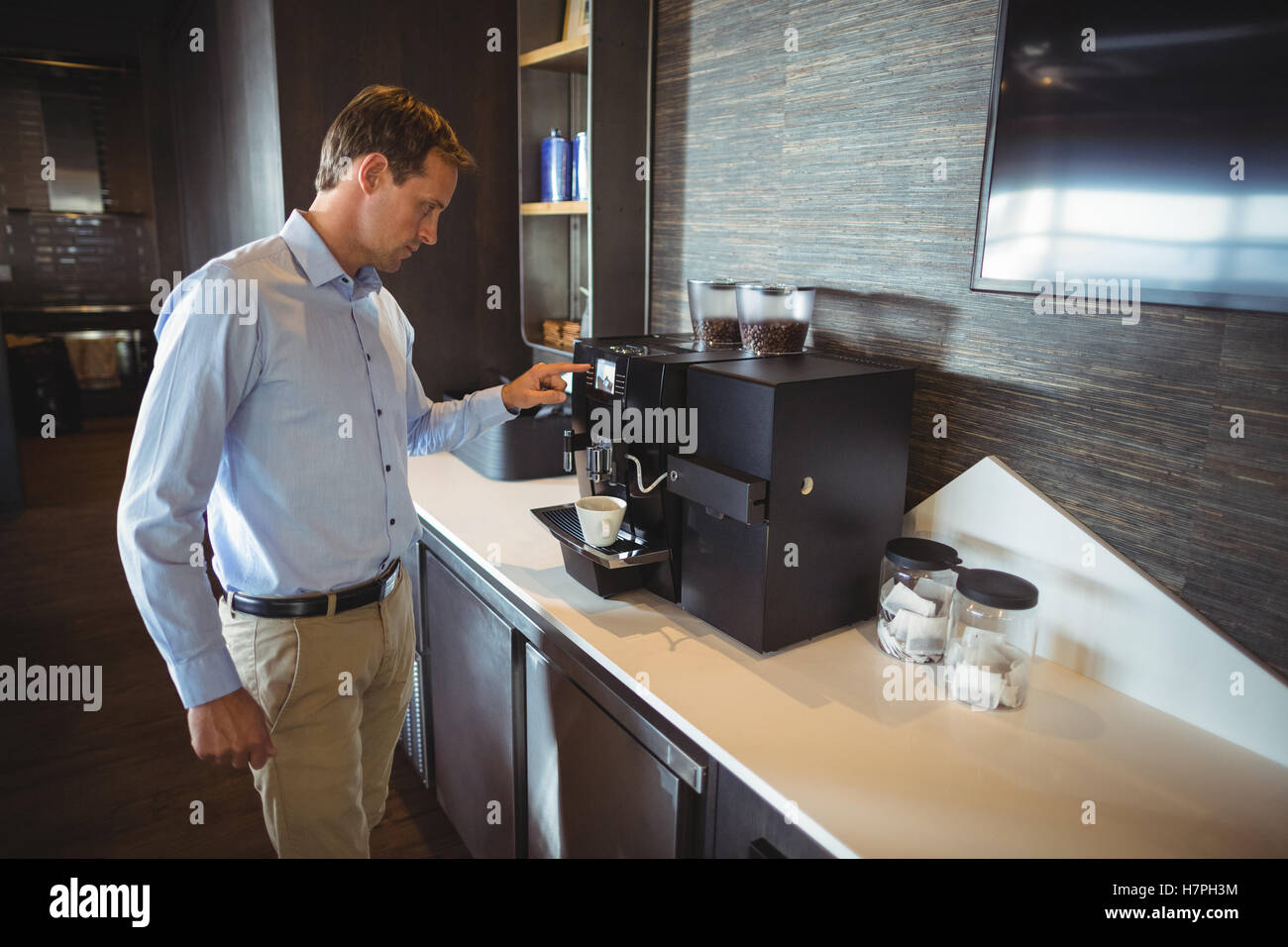 Businessman preparing coffee in coffee maker Stock Photo - Alamy