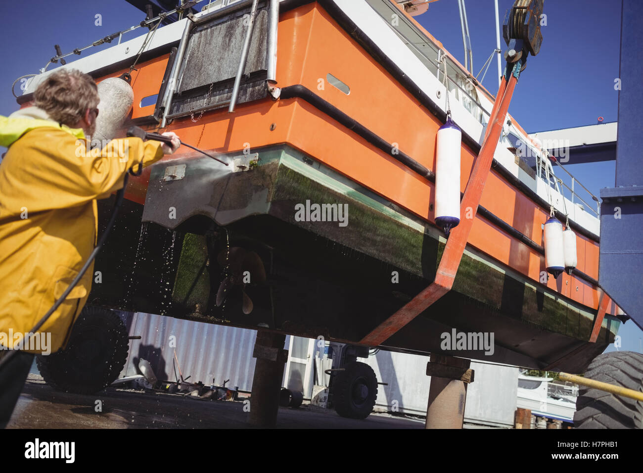 Man cleaning boat with pressure washer Stock Photo Alamy