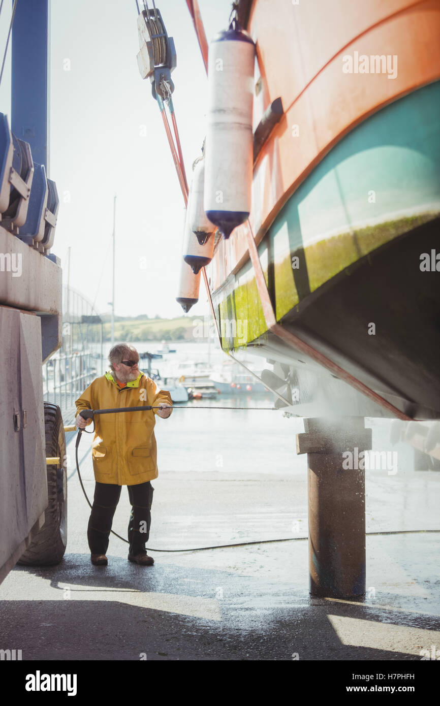 Man cleaning boat with pressure washer Stock Photo Alamy