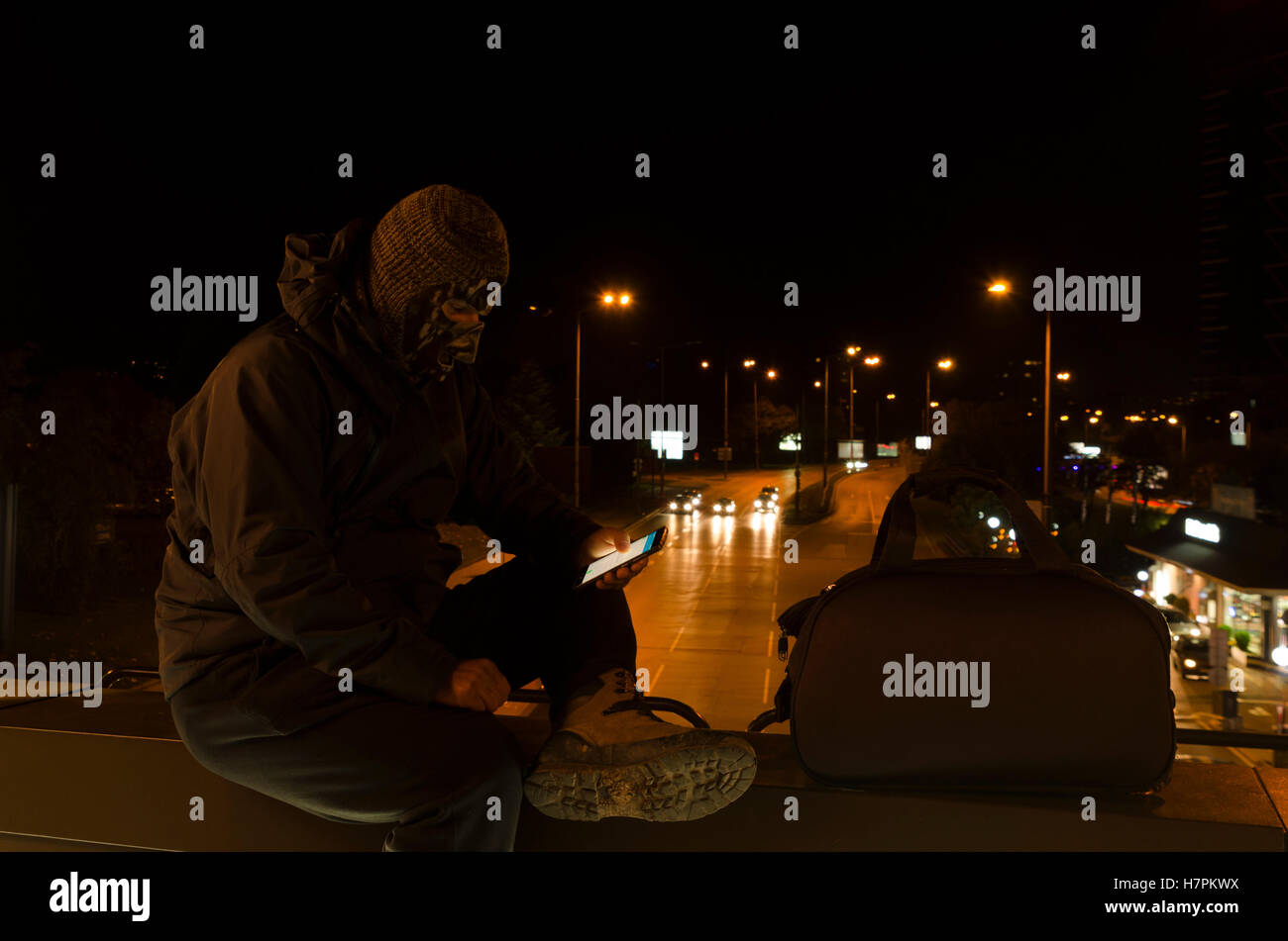 Terrorist in the center of a city sitting on a bridge Stock Photo