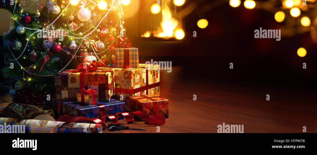 Christmas tree and holidays present on cfireplace red background Stock Photo