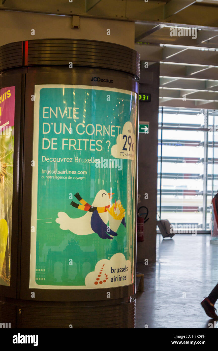 A sign showing a cone of chips advertising cheap flights to Brussels, Toulouse airport, Blagnac, Haute-Garonne, Occitanie France Stock Photo