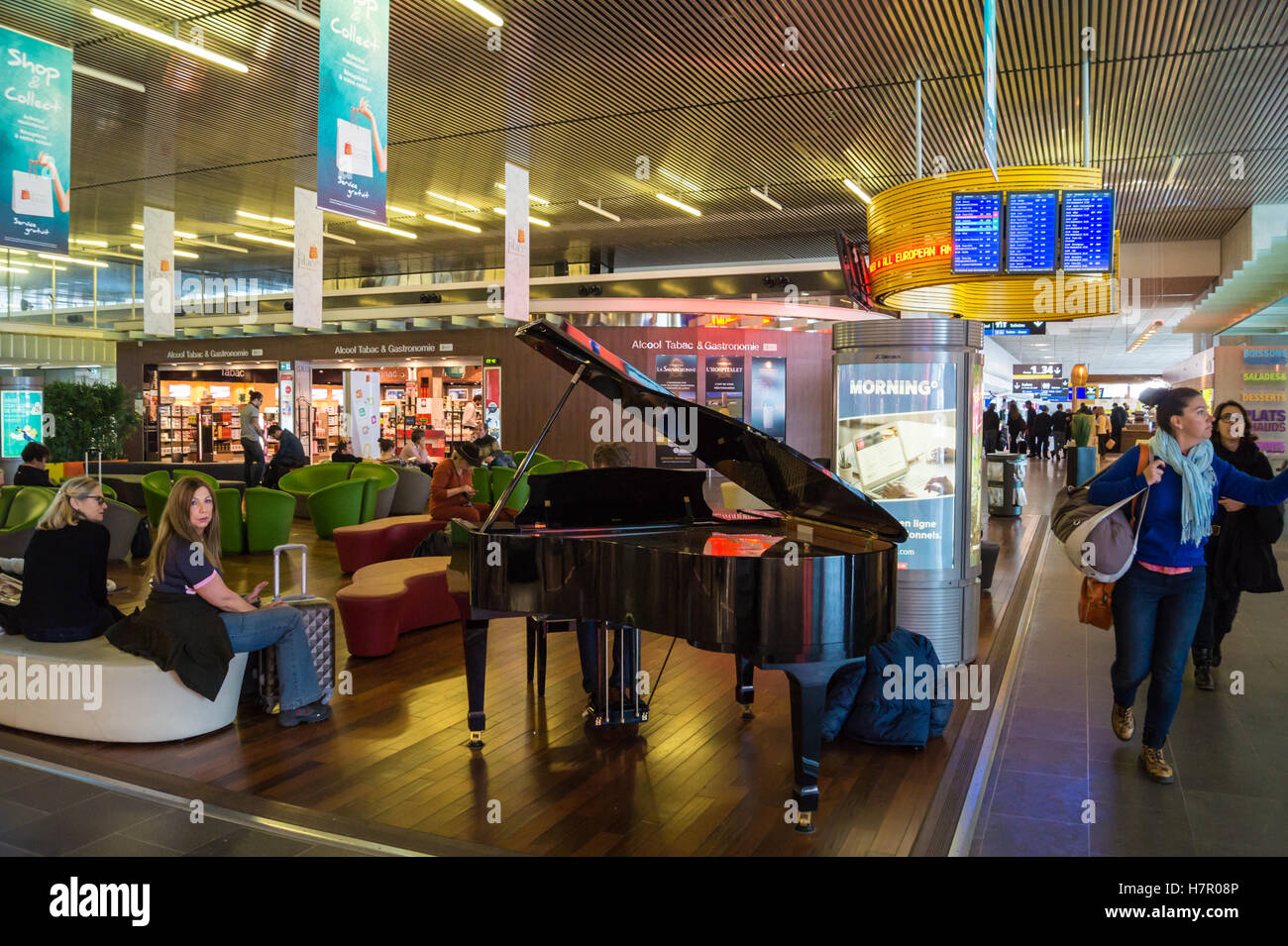 A passenger playing a public baby grand piano in the departures hall  Toulouse airport, Blagnac, Haute-Garonne, Occitanie, France Stock Photo -  Alamy